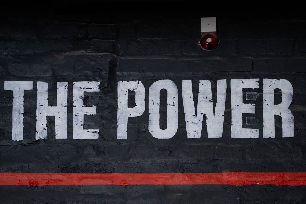 Close-up of 'The Power' graffiti on a dark wall, emphasizing strength and impact.